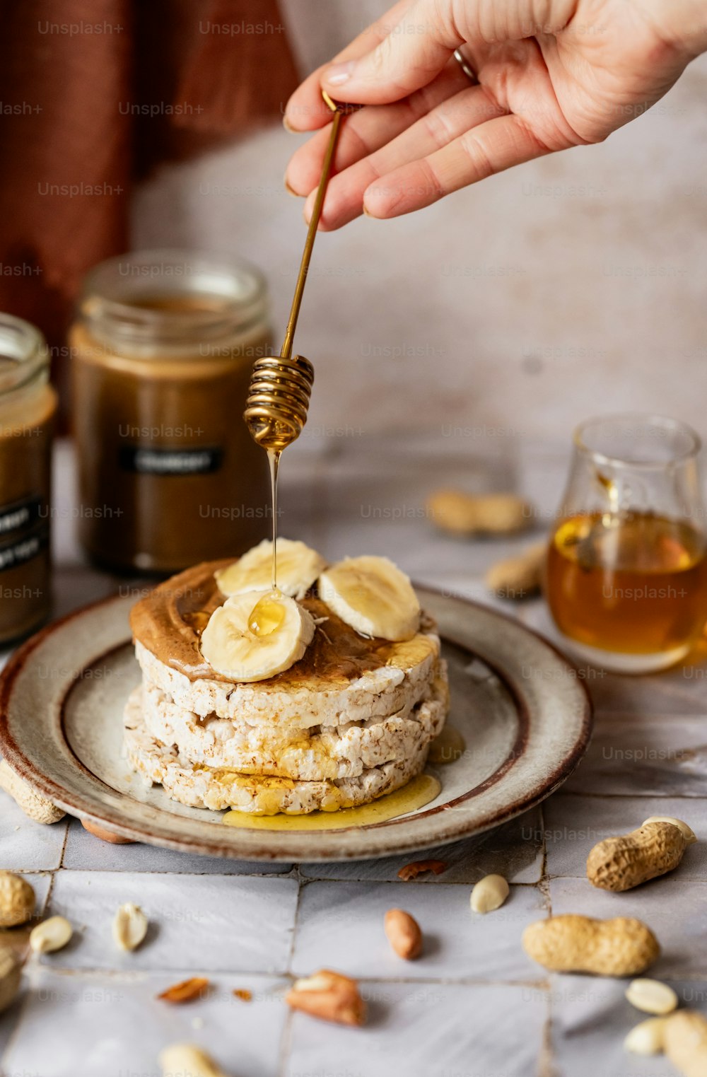 a person holding a spoon over a stack of pancakes