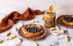 a jar of peanut butter and a plate of blueberries