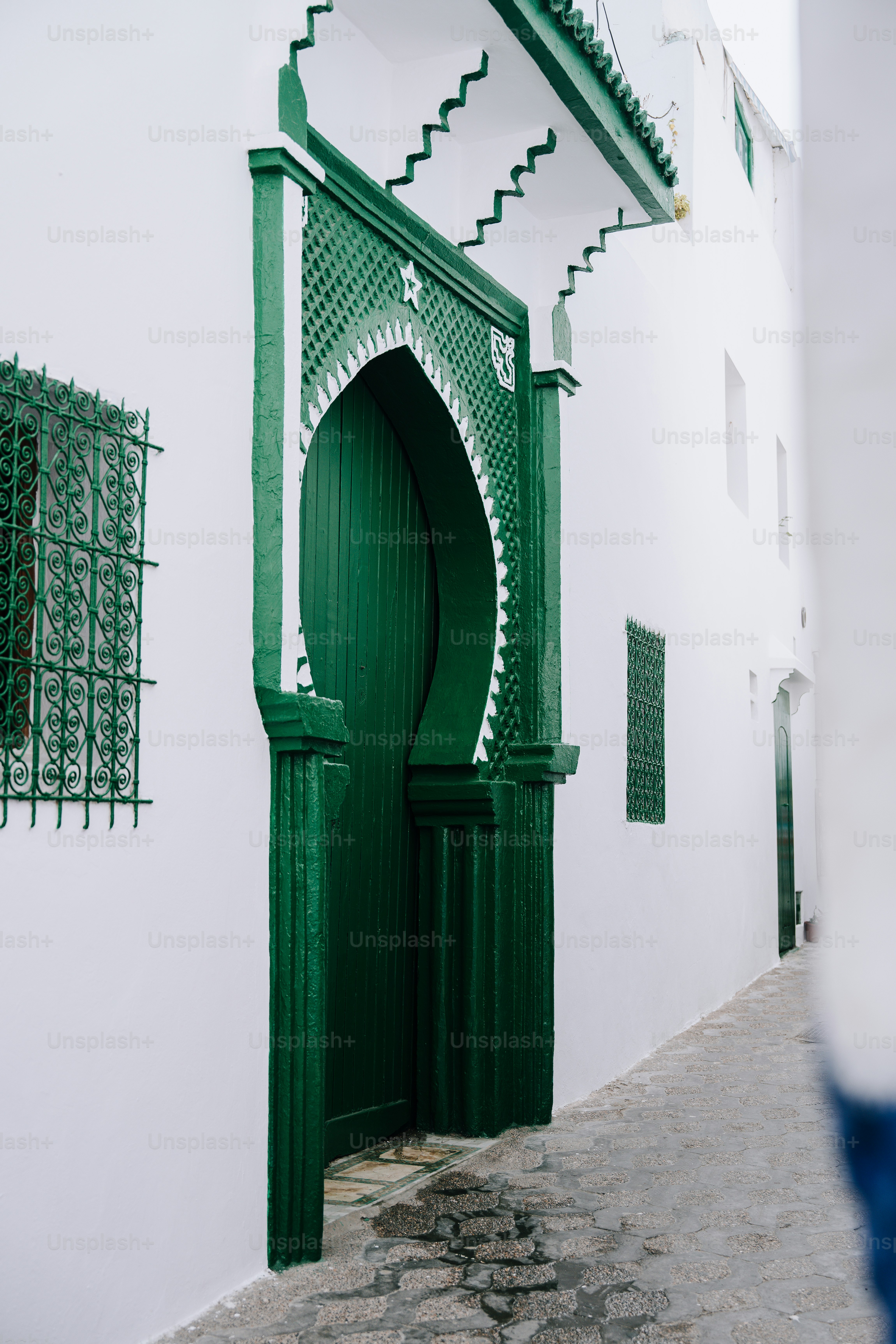 a white building with a green door and window