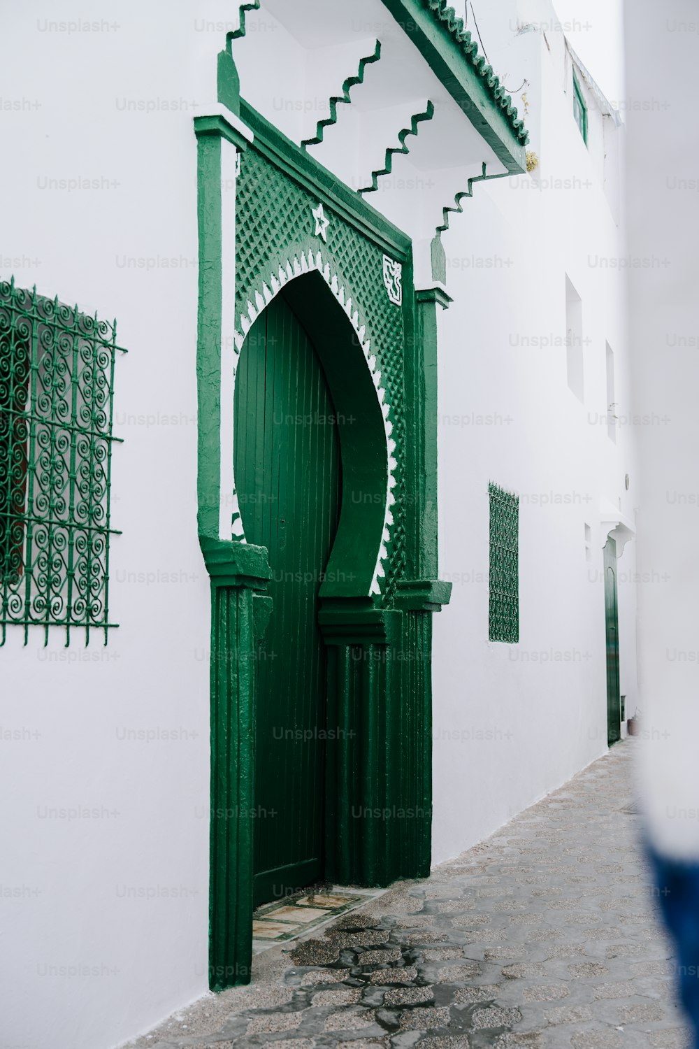 초록색 문과 창문이 있는 흰색 건물