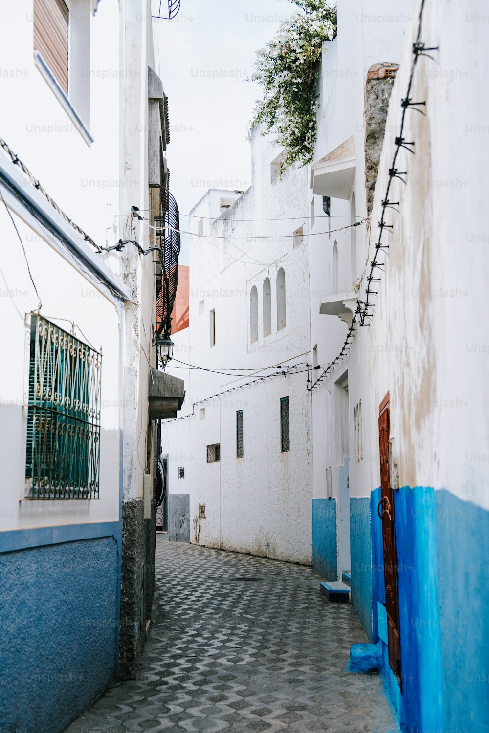 Un callejón estrecho con edificios blancos y adornos azules