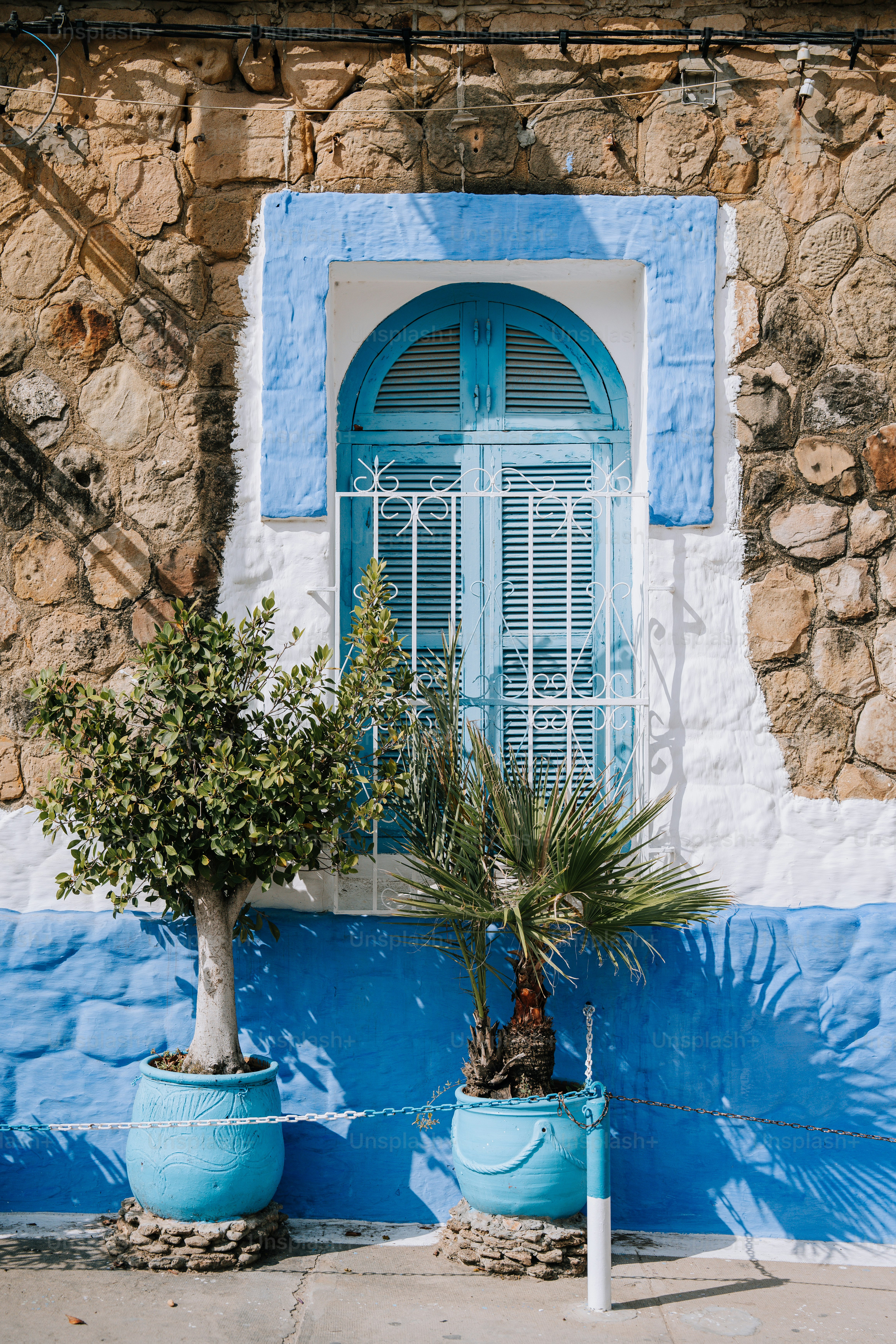 un bâtiment bleu et blanc avec un arbre devant lui