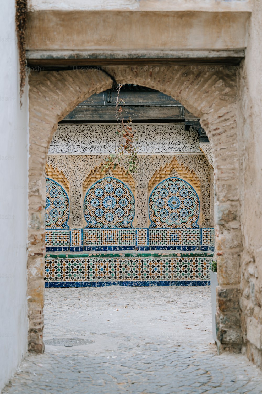 Un arco en un edificio con un diseño de azulejos decorativos