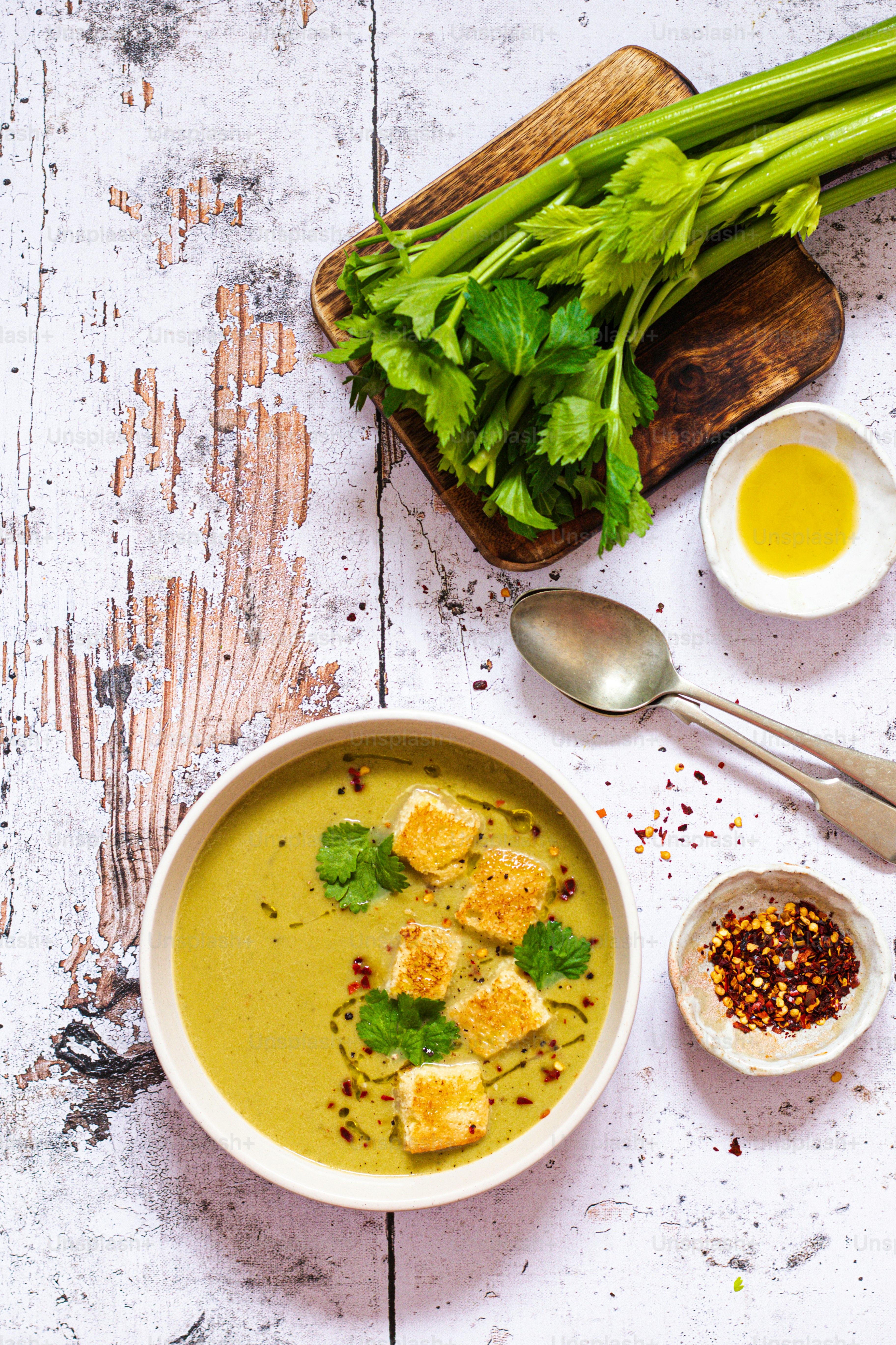 a bowl of soup with tofu and green vegetables
