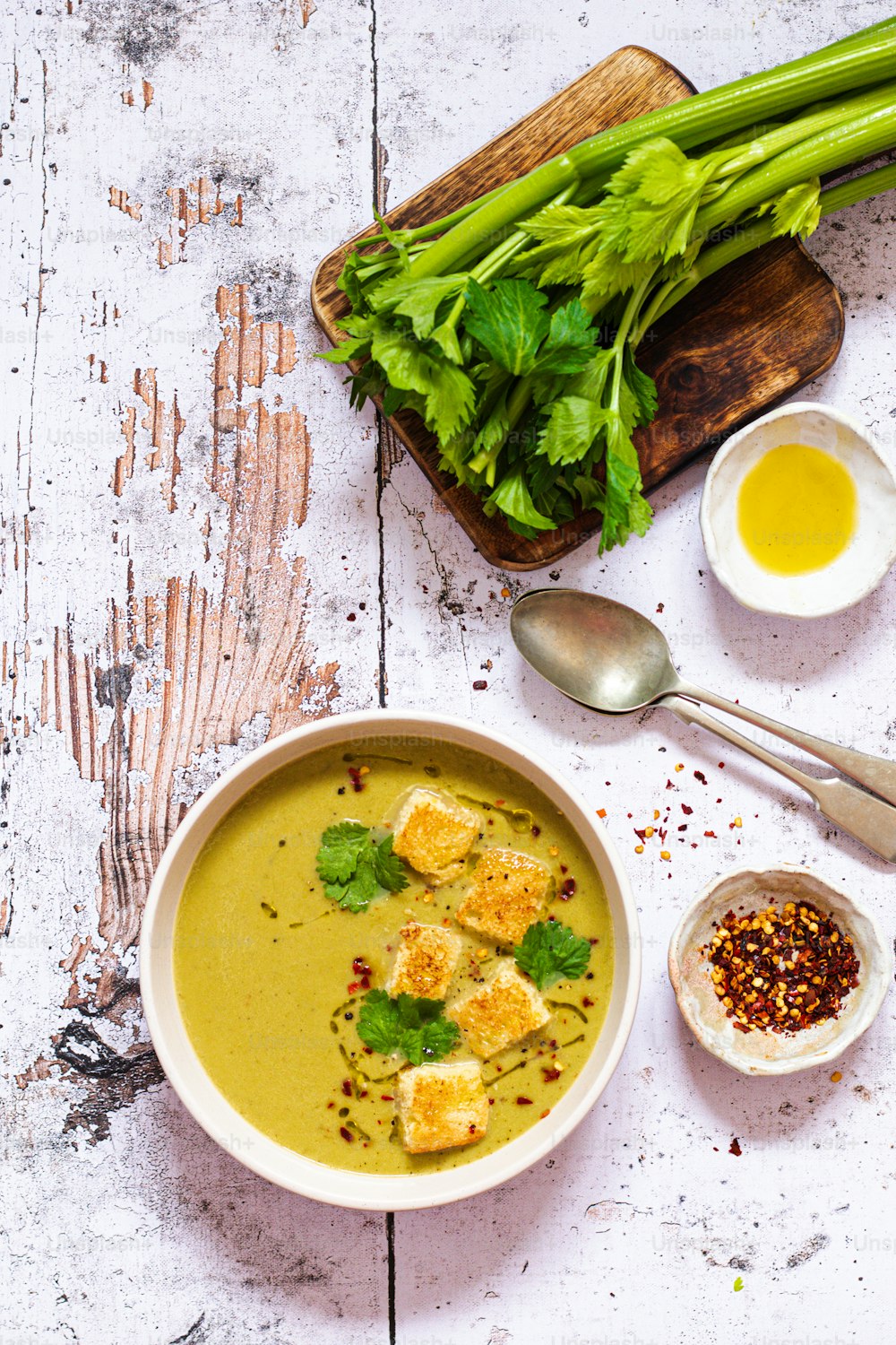 un bol de soupe avec du tofu et des légumes verts