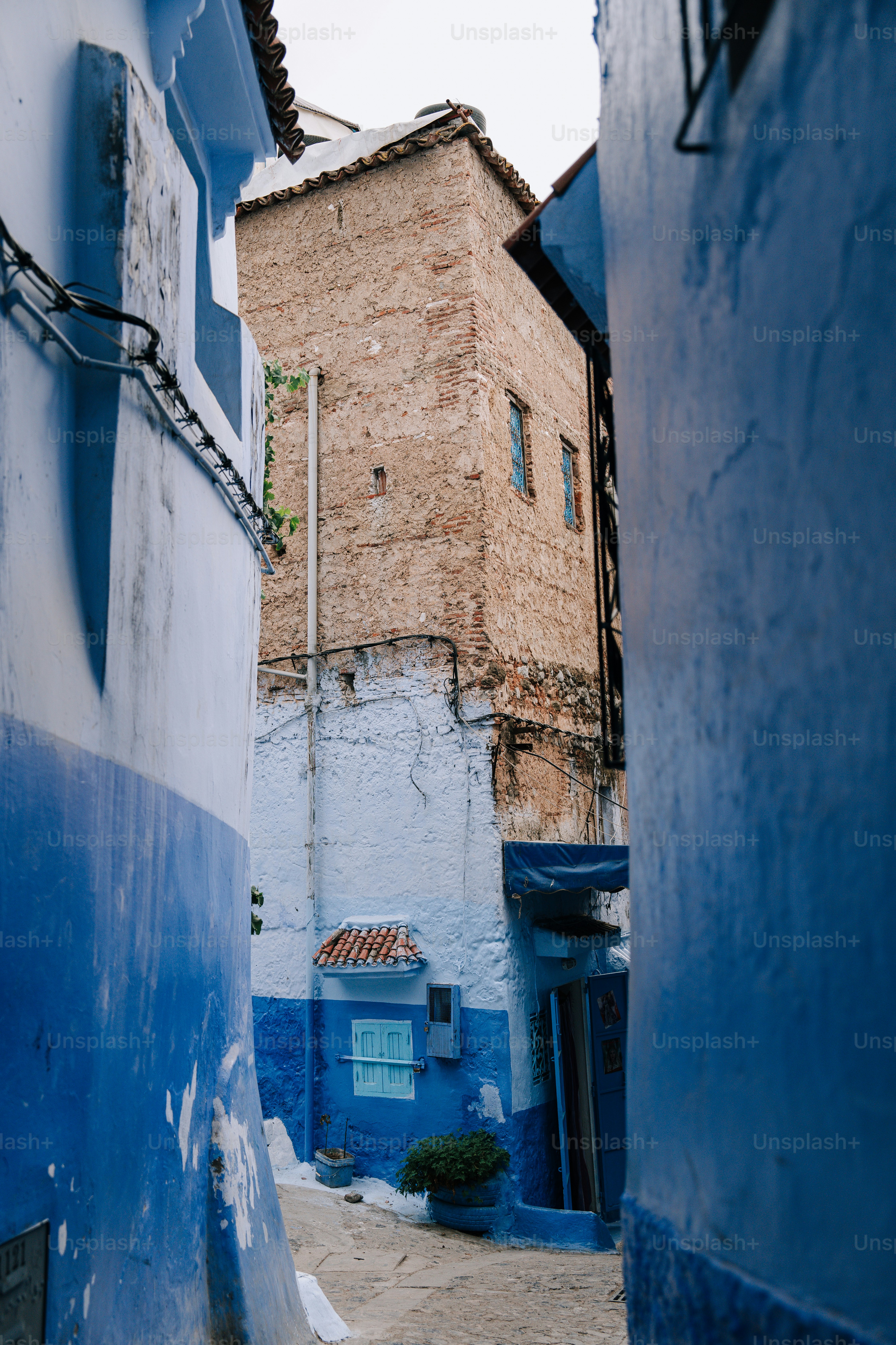a narrow alley way with a brick building in the background