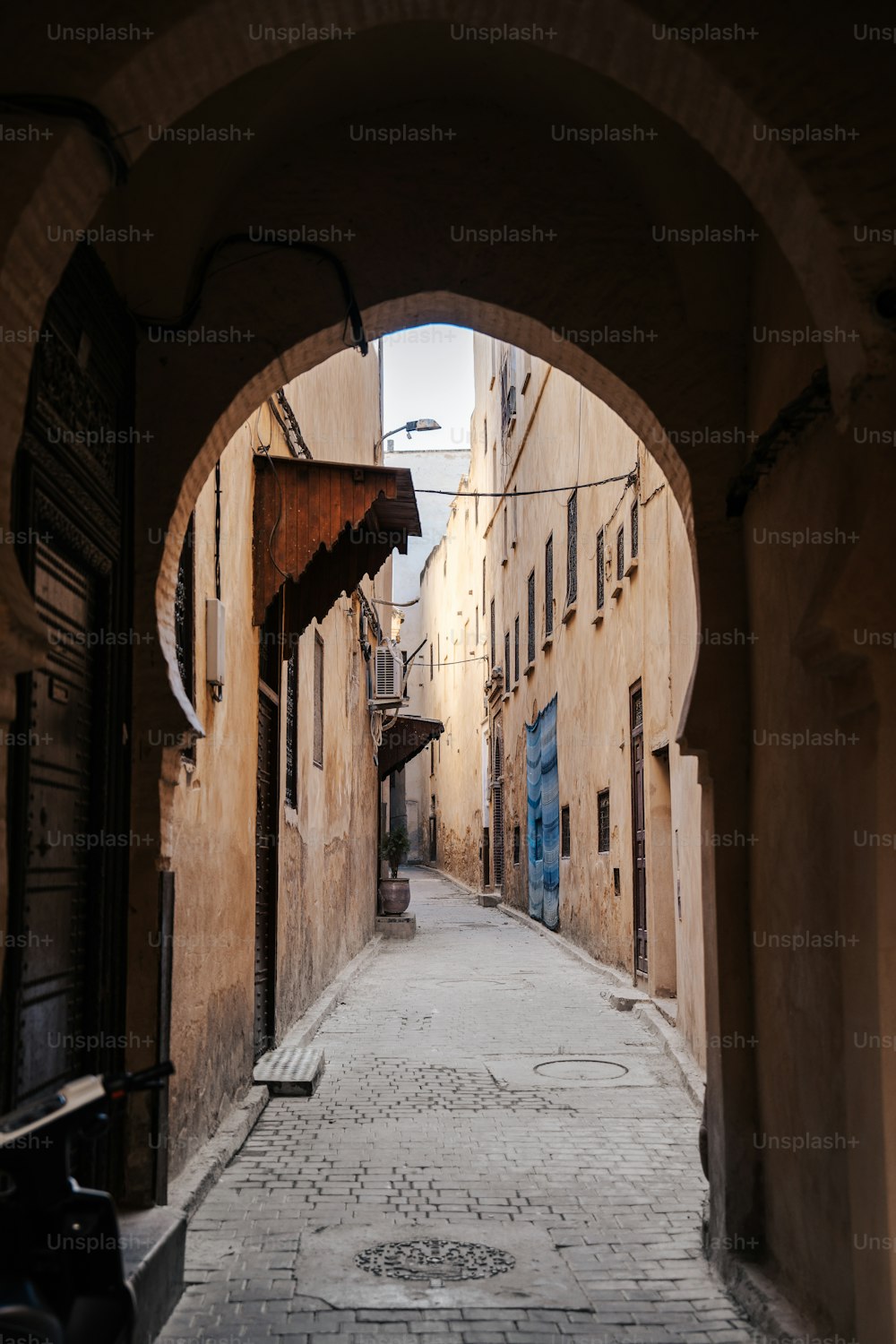 a narrow alley way with an arch leading to a building