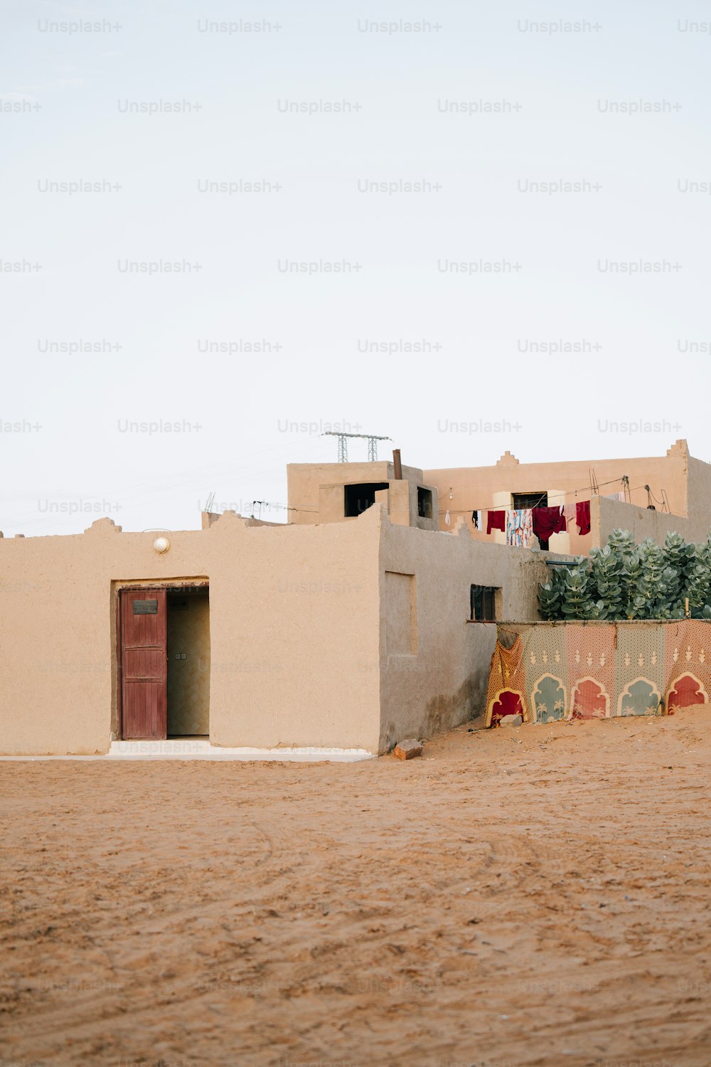 un bâtiment en pisé avec une porte et une fenêtre rouges