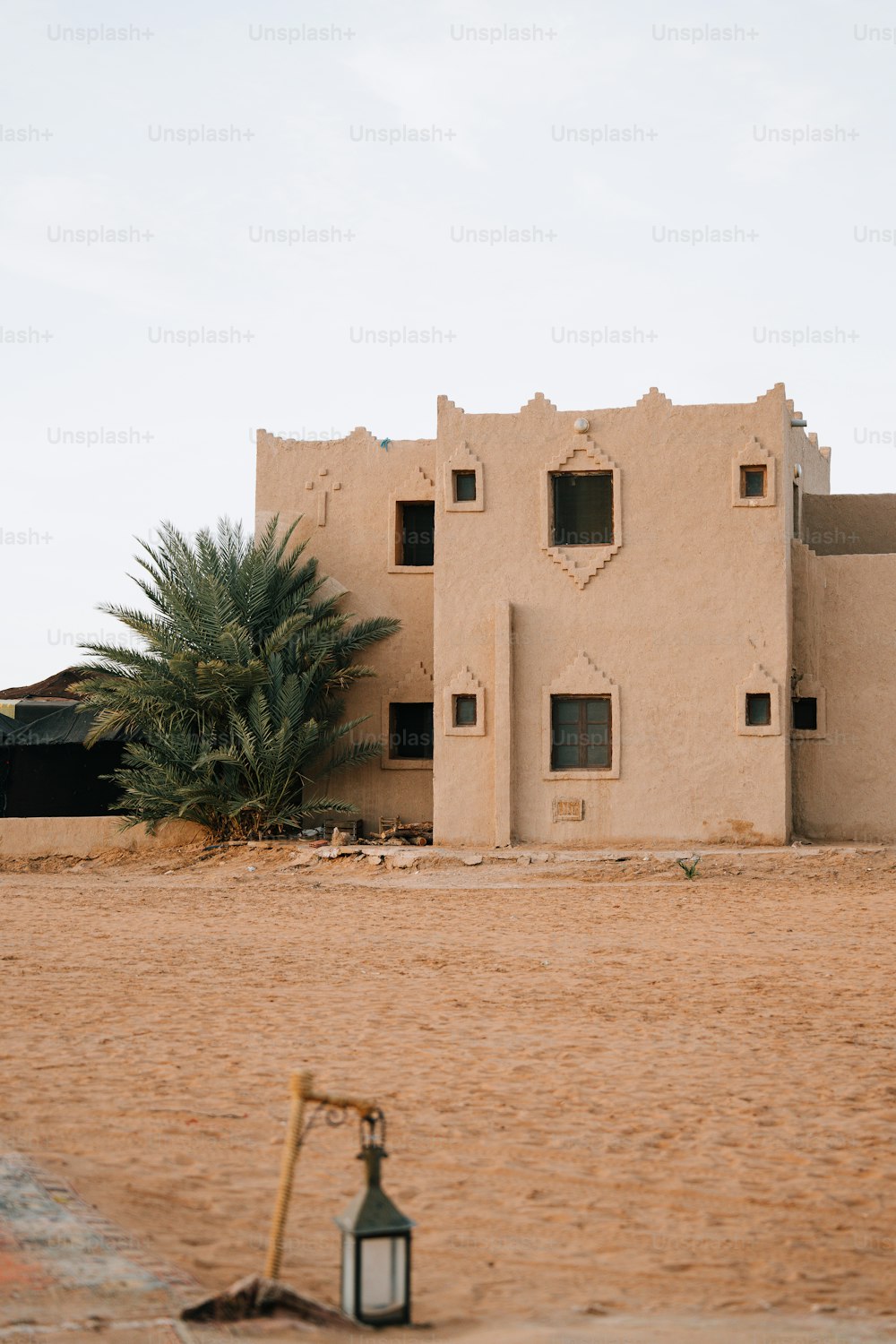 uma casa no deserto com uma lanterna à sua frente