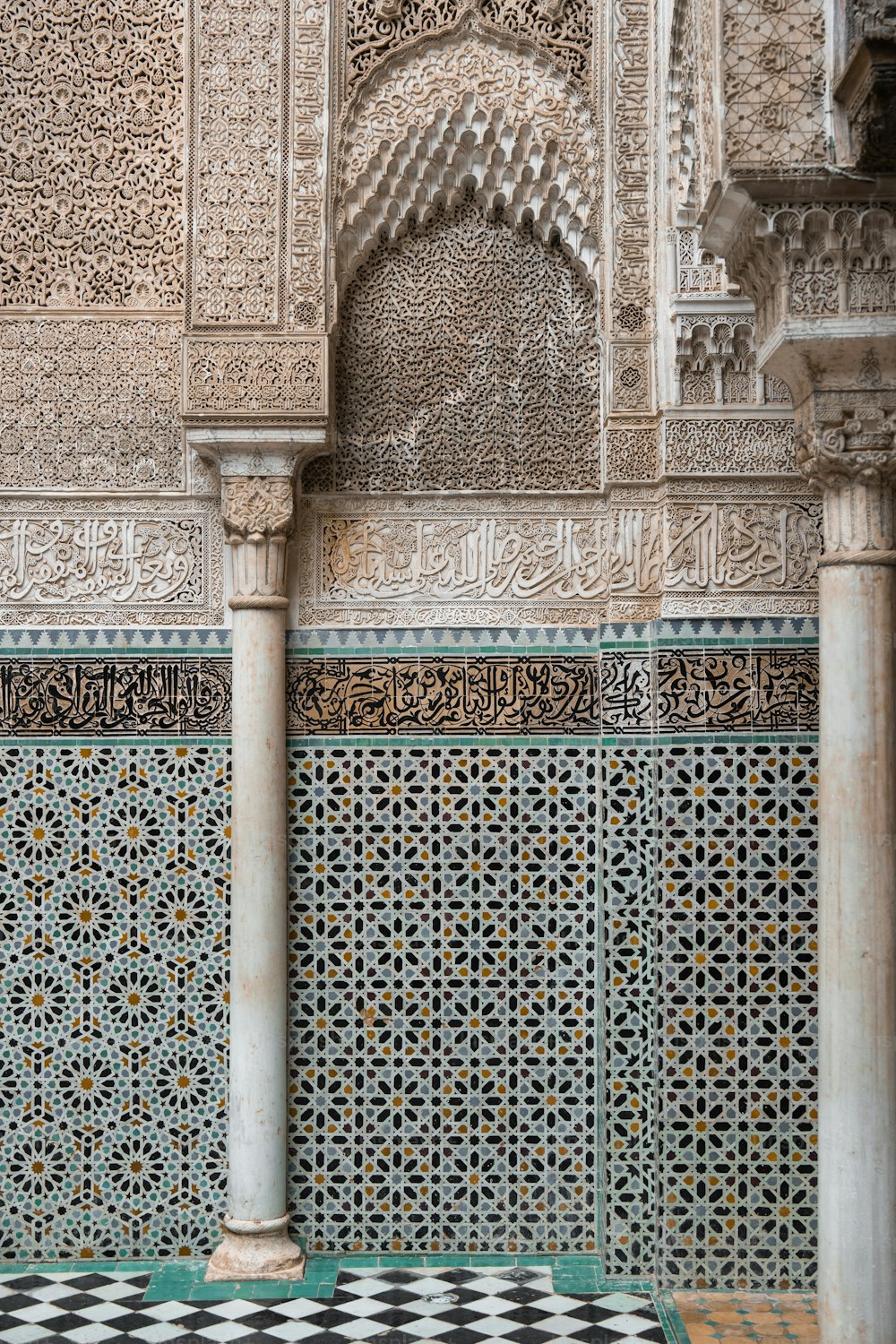 uma parede ornamentada com piso quadriculado e colunas