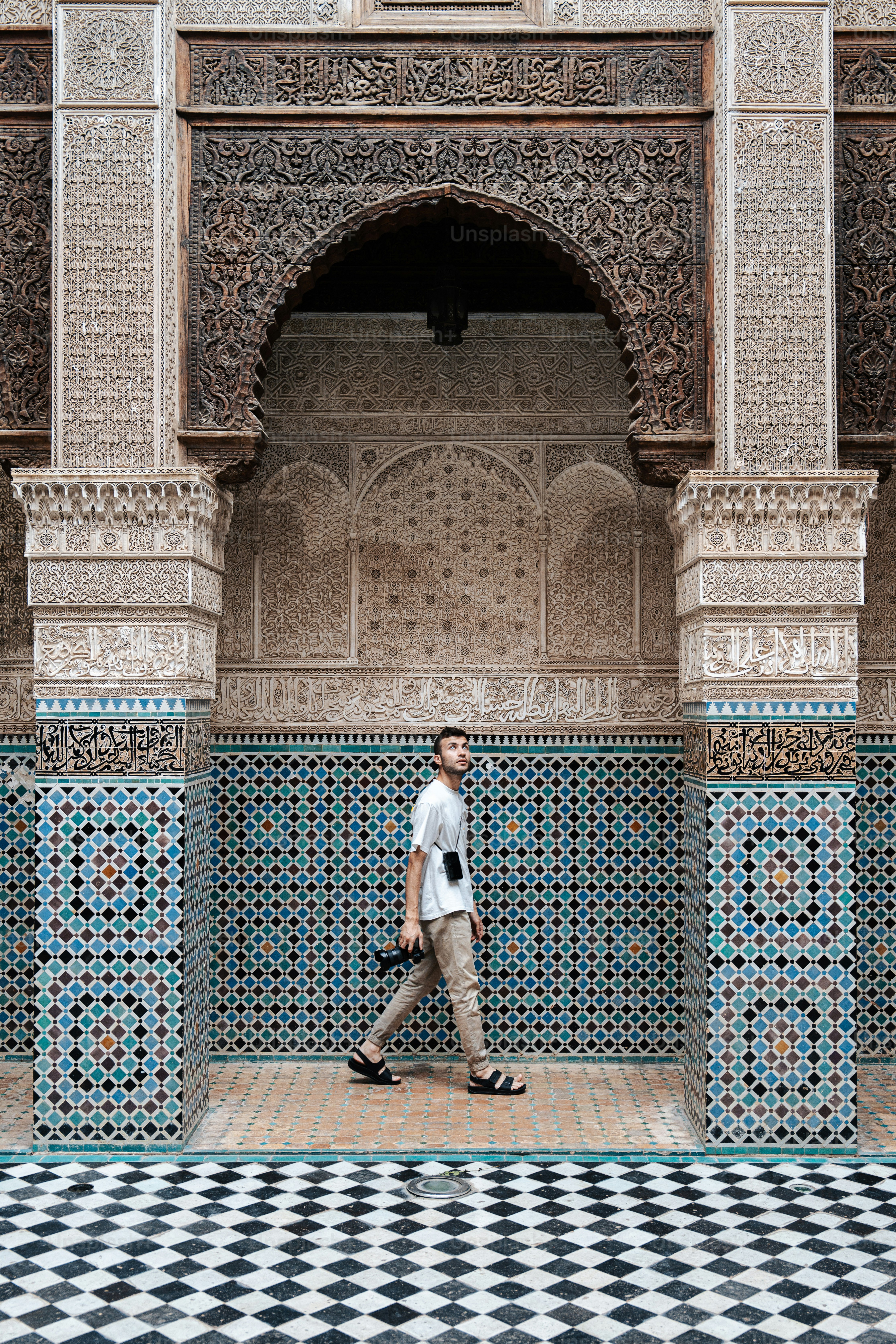 a man walking in front of a building with a checkered floor