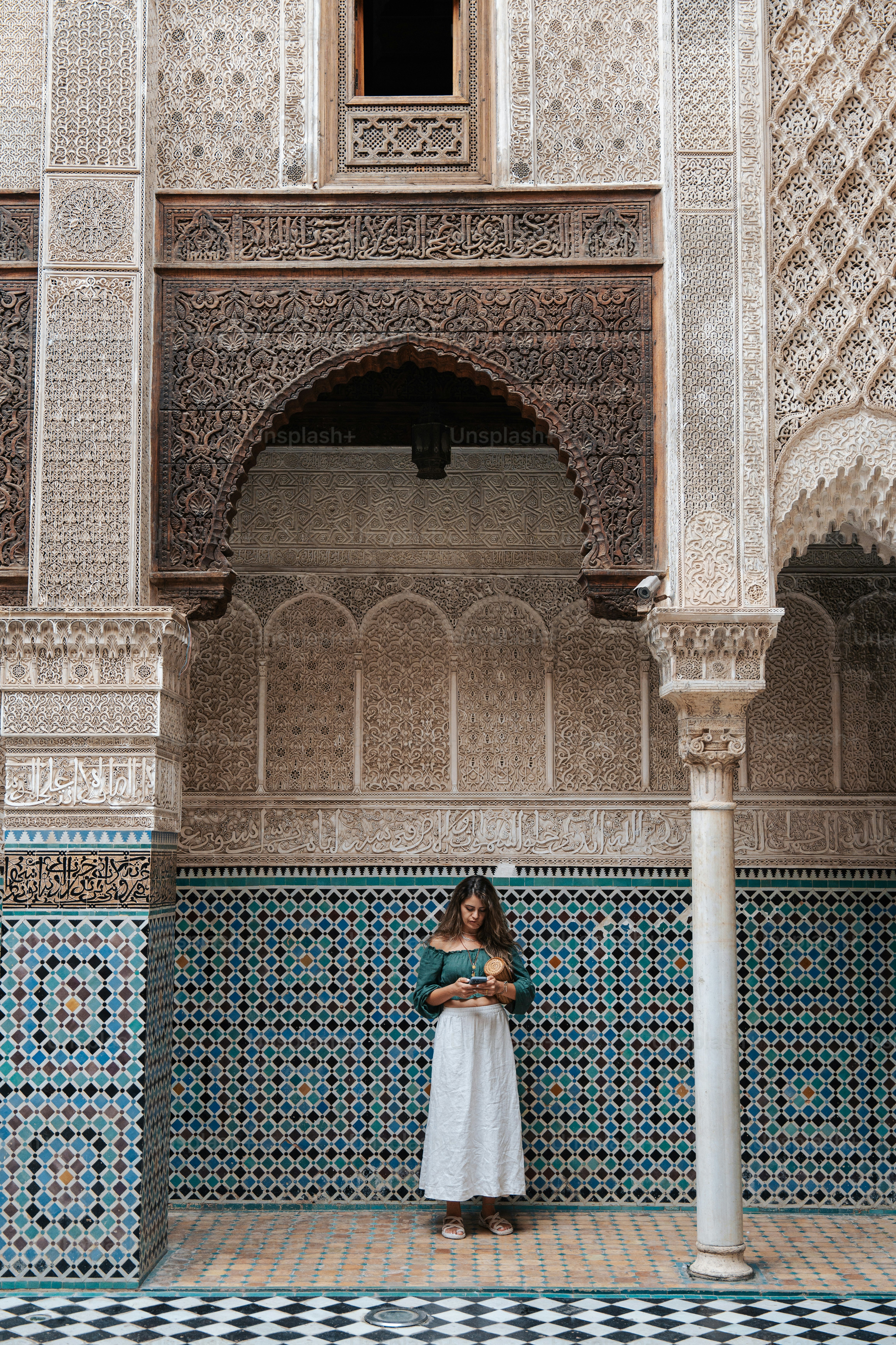 a woman standing in front of a blue and white wall