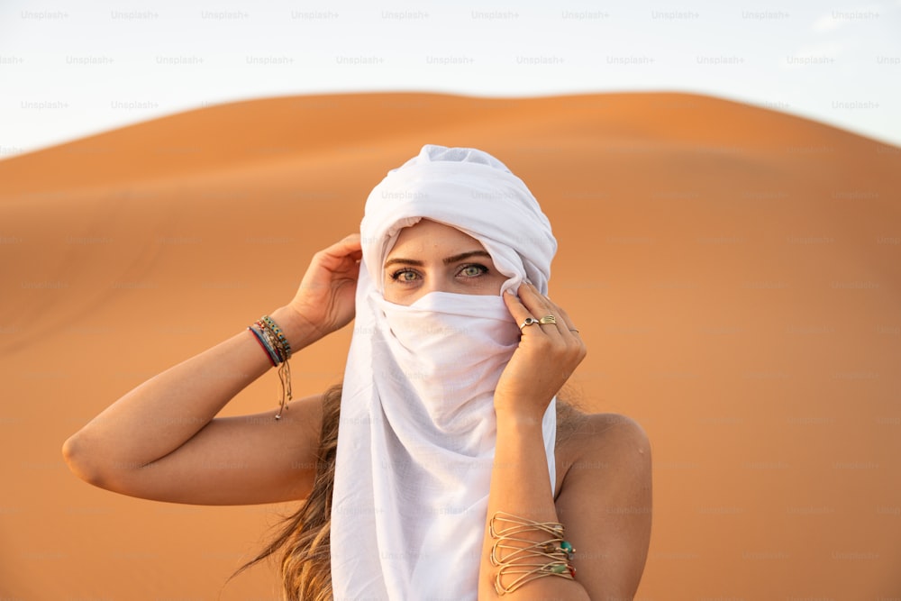 사막에서 흰 머리 덮개를 쓴 여자