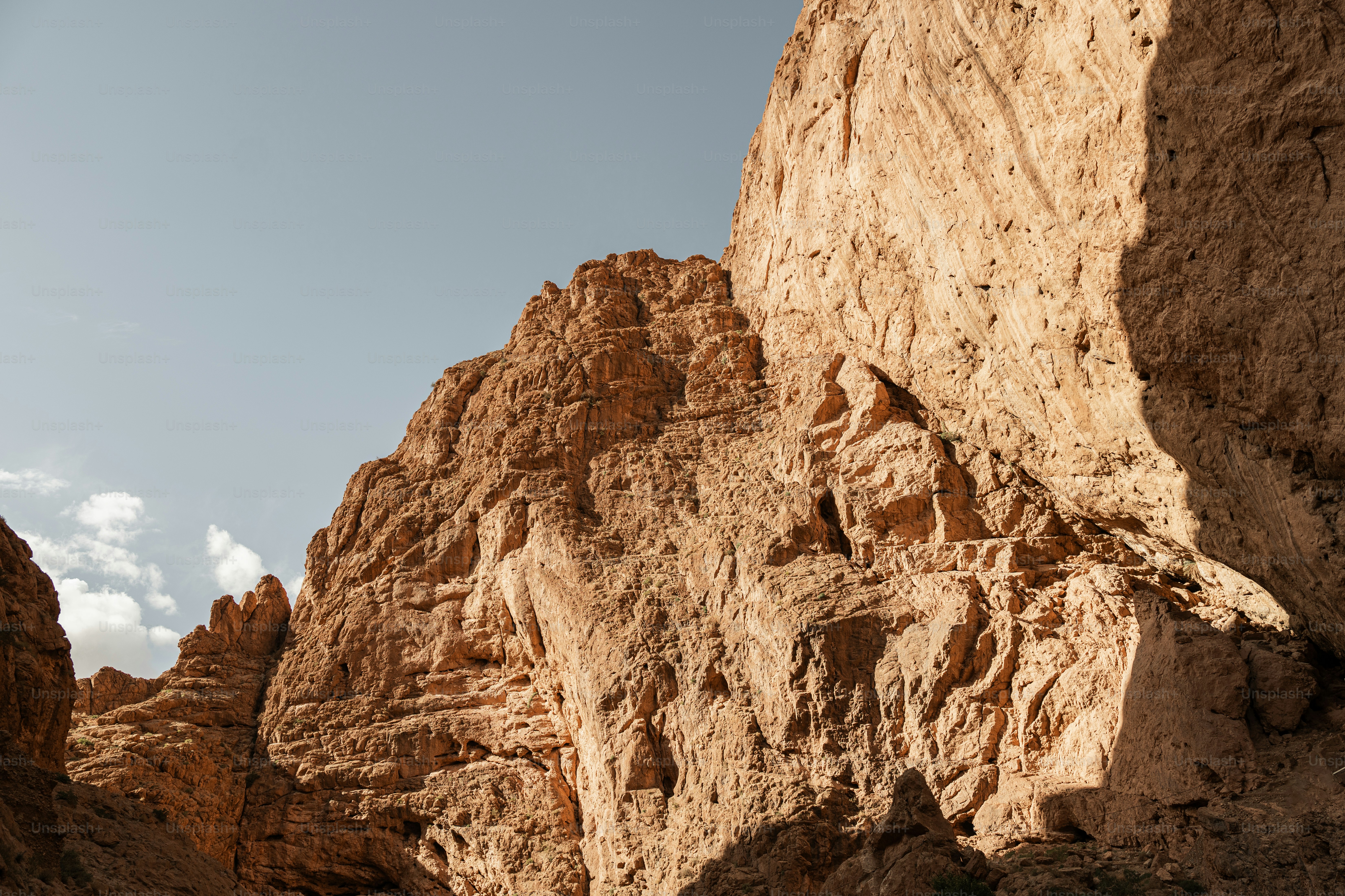 a large rock formation with a sky in the background