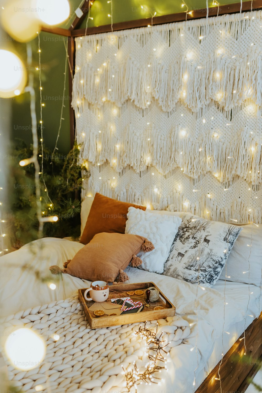 una cama con cabecero blanco y una guirnalda de luces