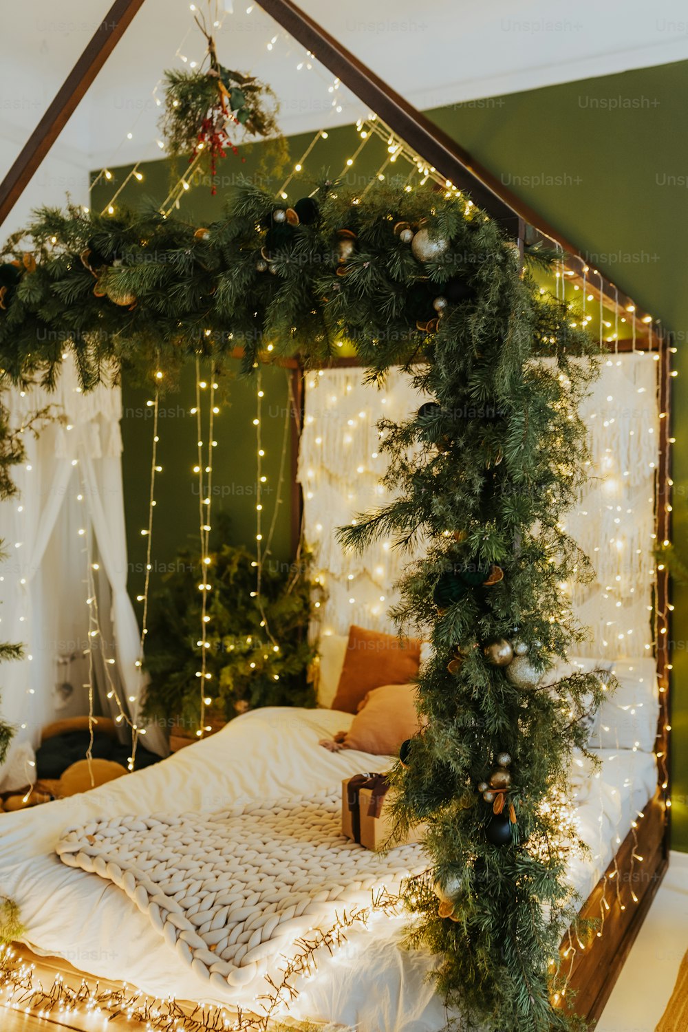 크리스마스 조명으로 덮인 캐노피가 있는 ��침대