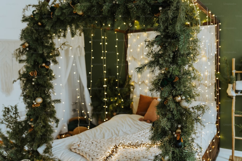 Uma cama coberta de luzes de Natal ao lado de uma parede verde