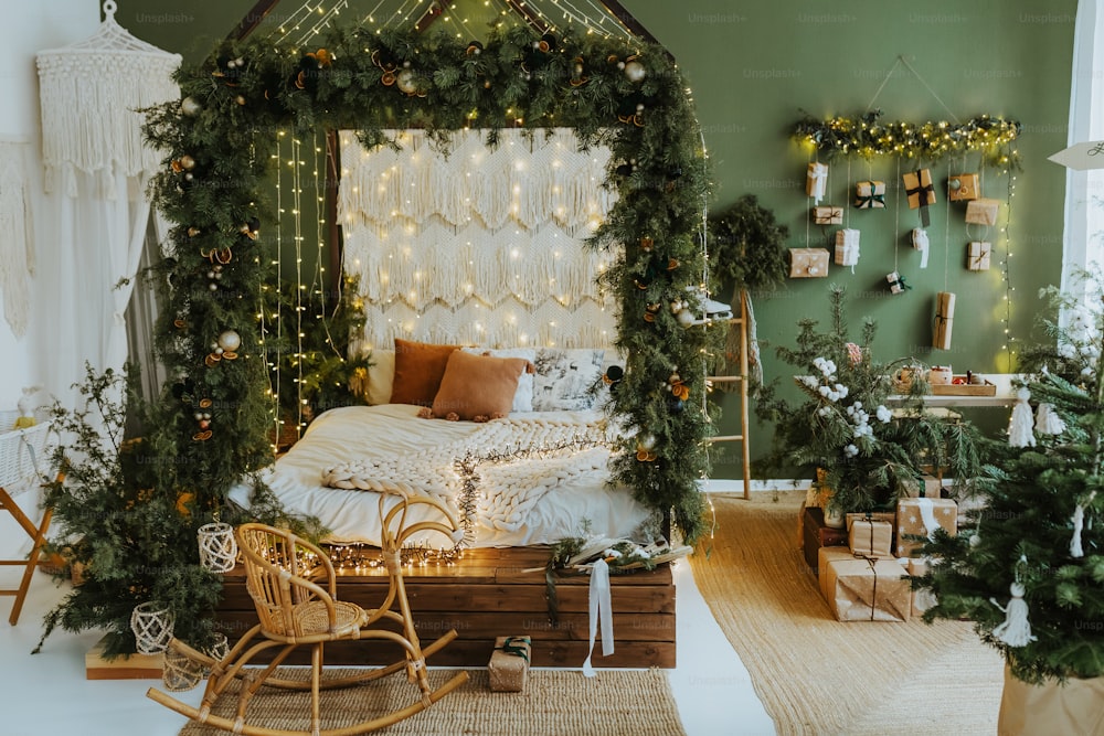 a bedroom decorated for christmas with a bed covered in greenery