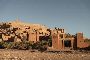 a village in the desert with a mountain in the background