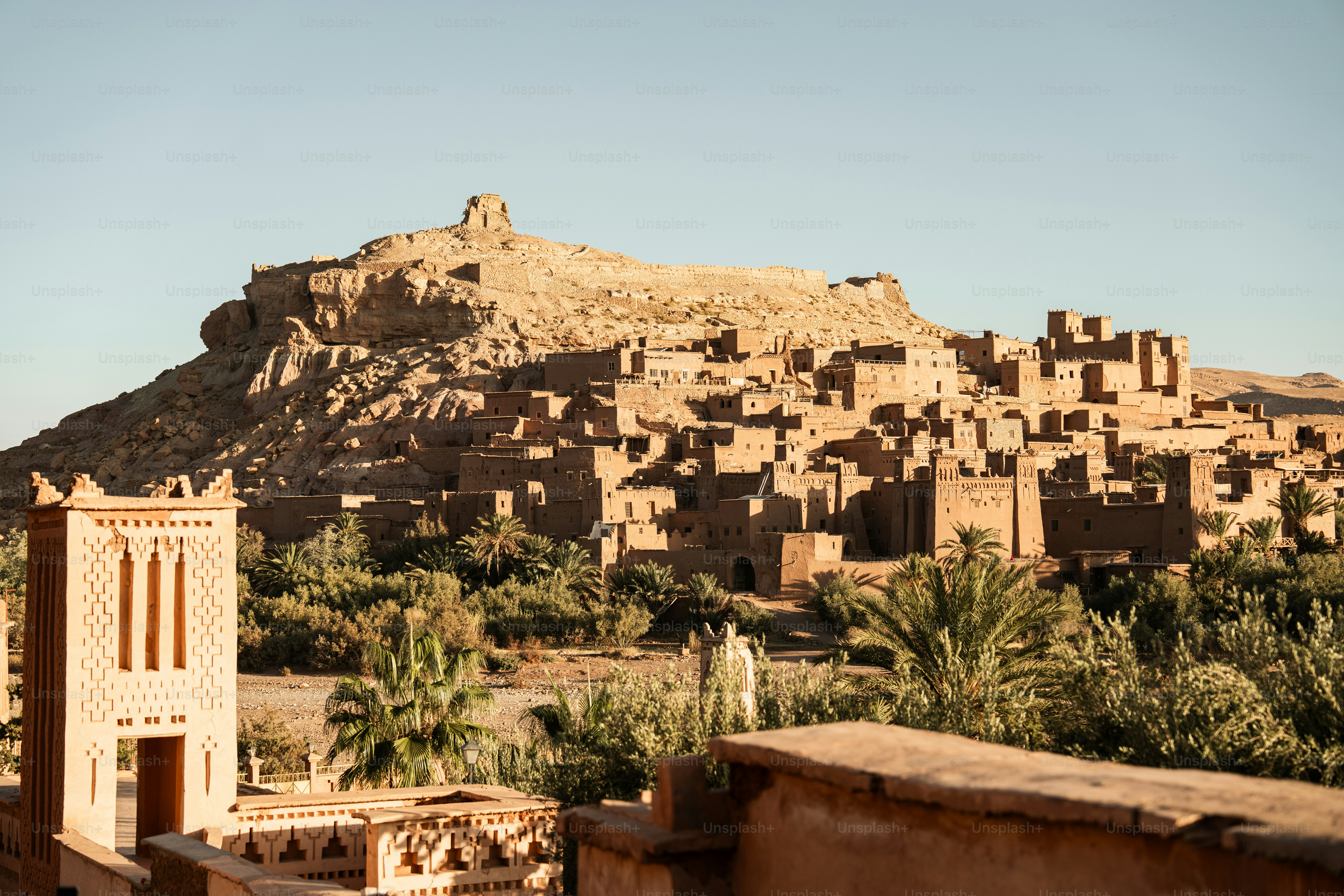 a village in the desert with a mountain in the background