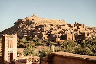 a village in the desert with a mountain in the background