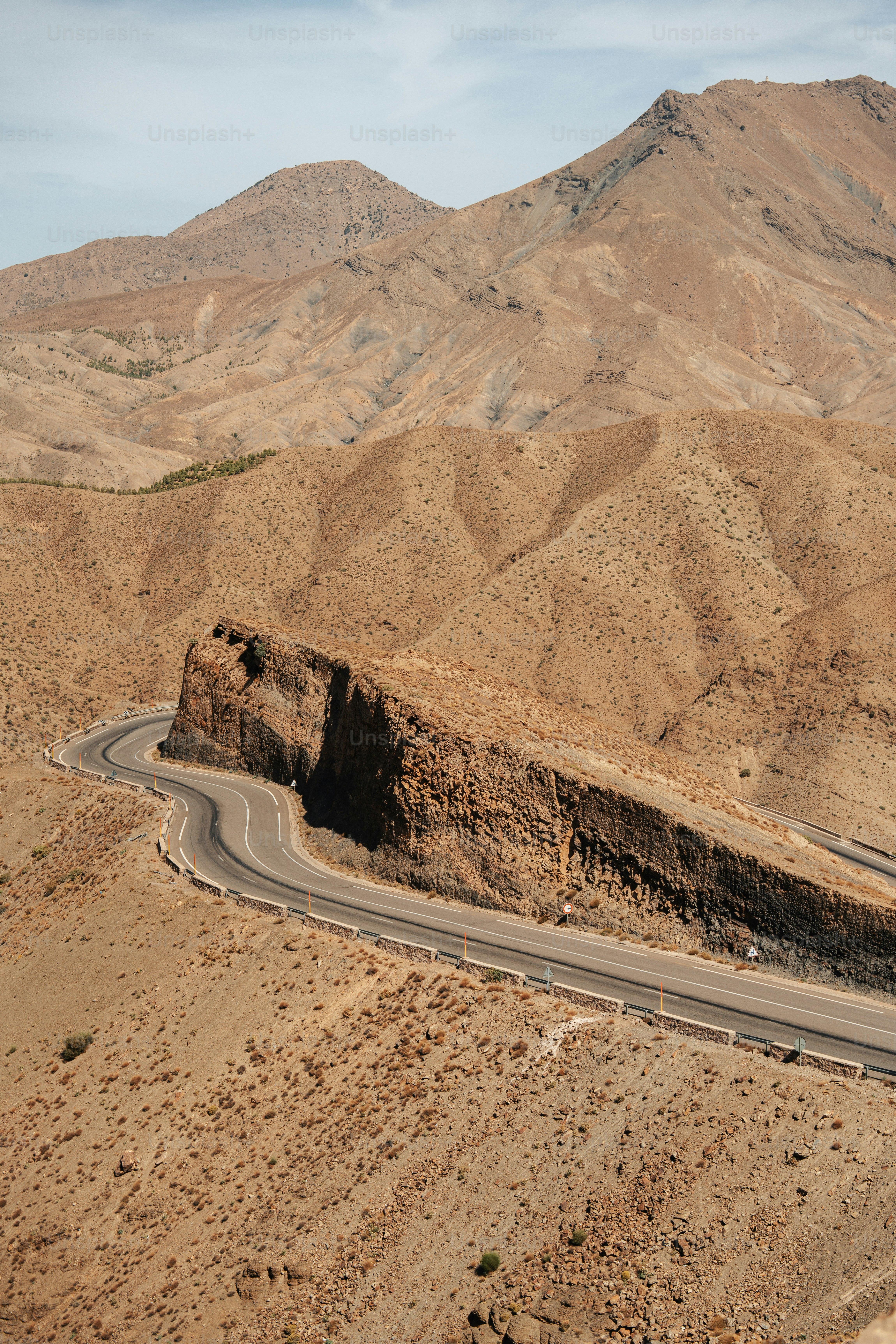 a road in the middle of a desert with mountains in the background