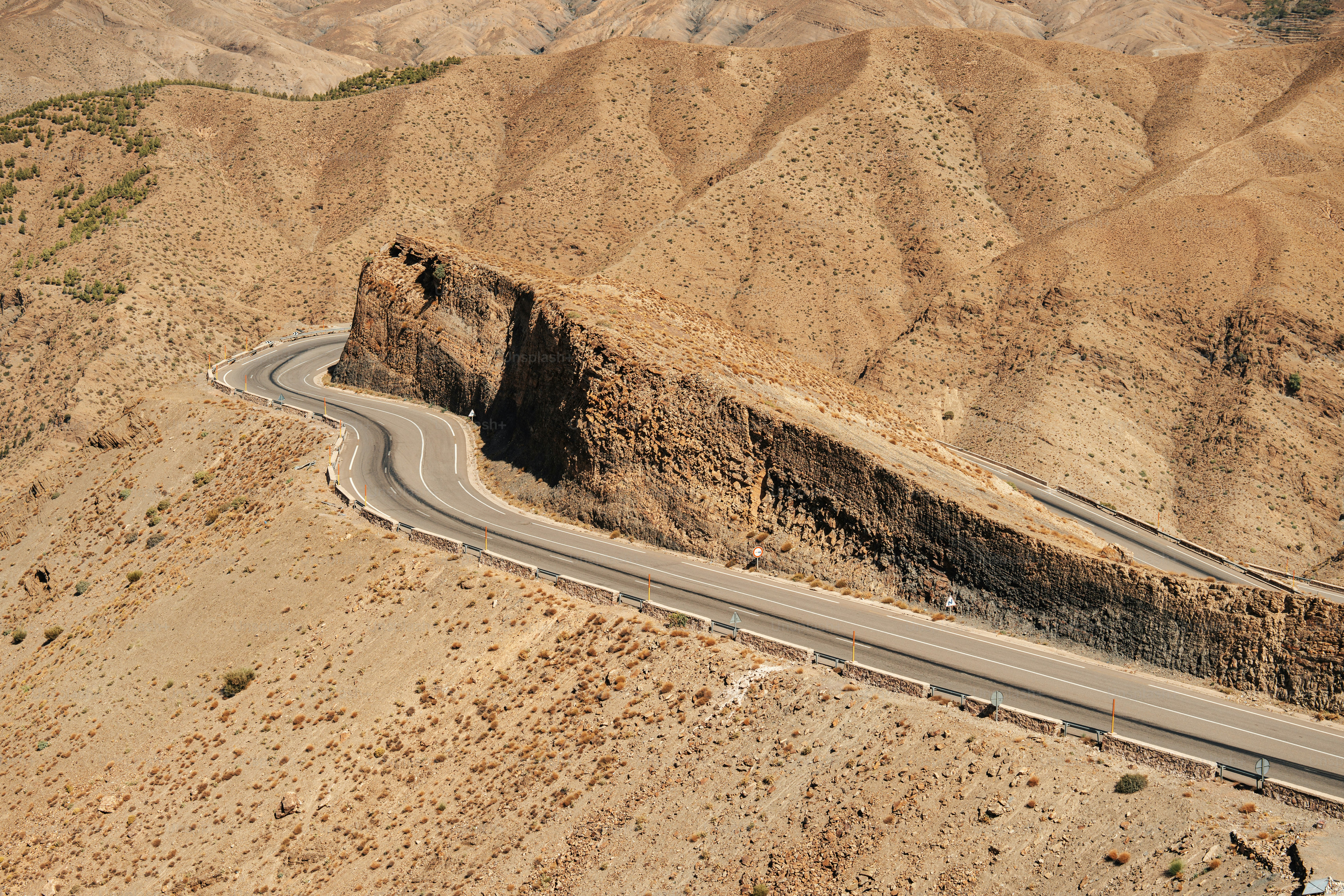 an aerial view of a winding road in the desert