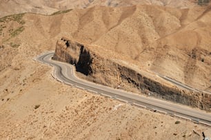 an aerial view of a winding road in the desert