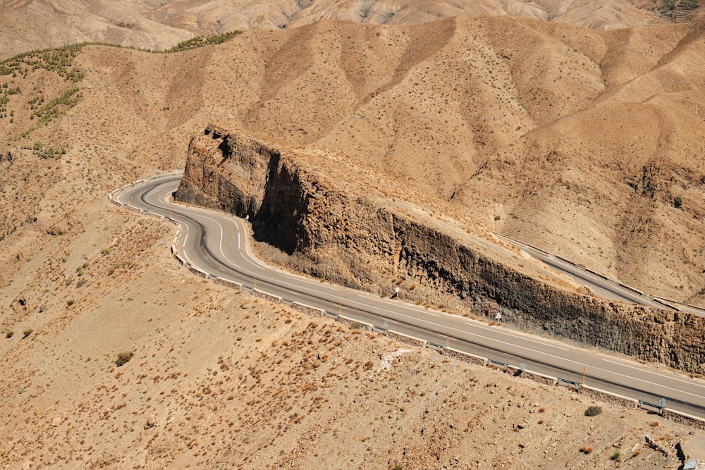 an aerial view of a winding road in the desert