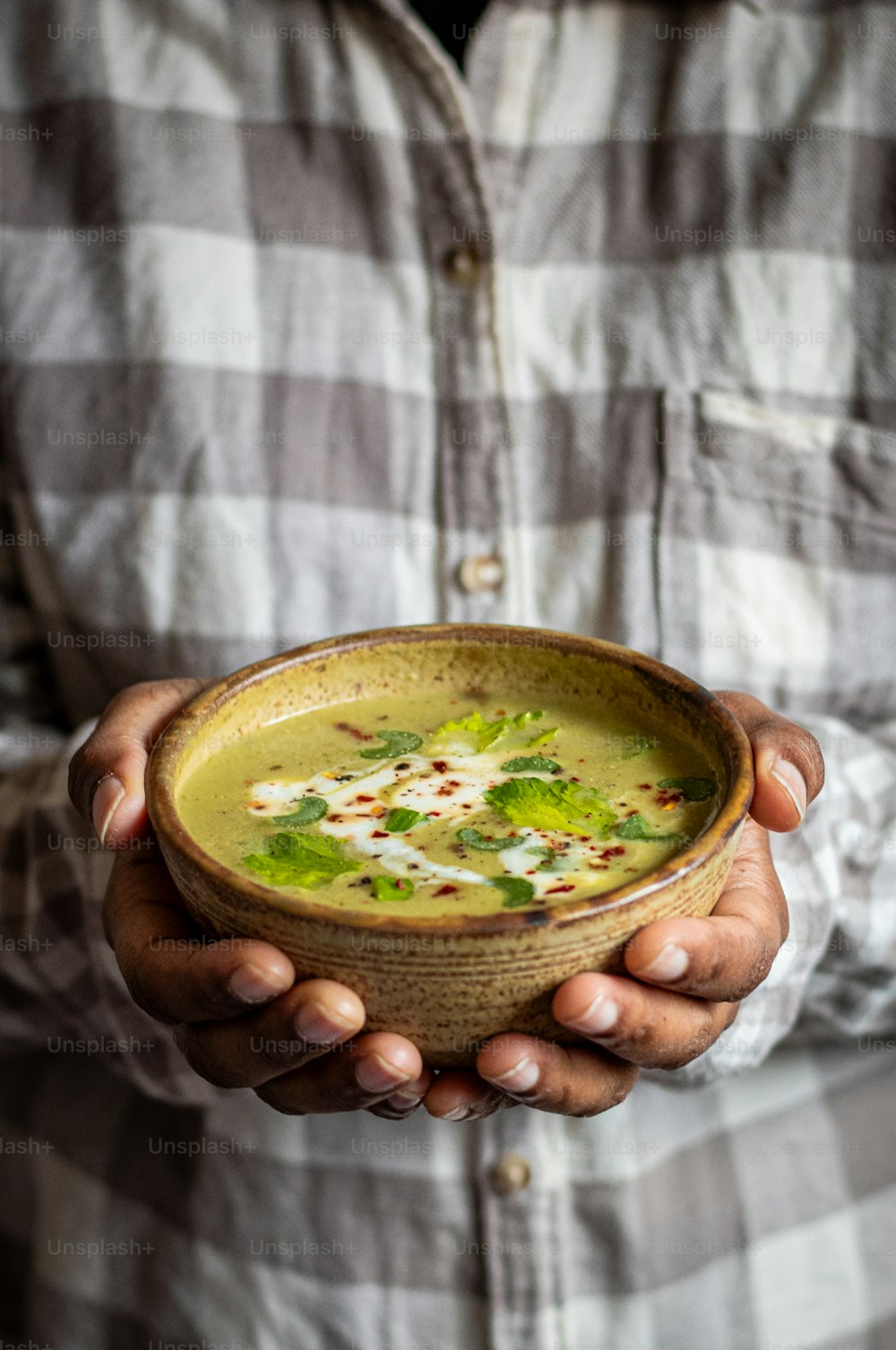 a man holding a bowl of soup in his hands