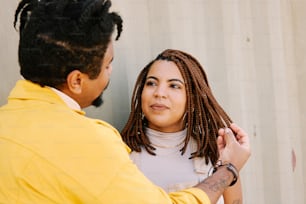 a man helping a woman with her dreadlocks