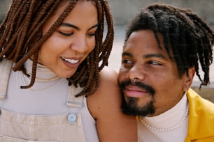 a man and a woman with dreadlocks are smiling