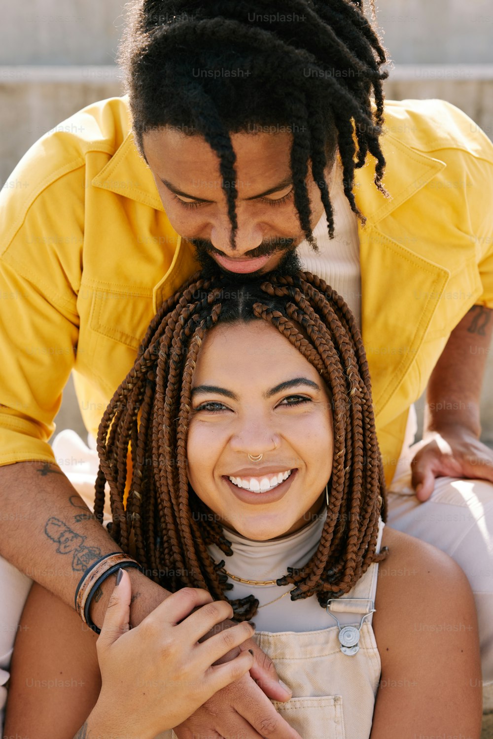 a man and a woman with dreadlocks are smiling