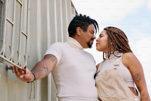 a man and a woman leaning against a wall