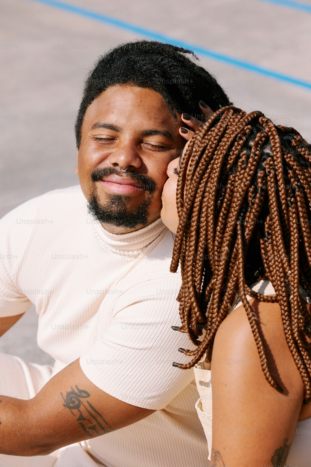 a man with dreadlocks sitting next to a woman