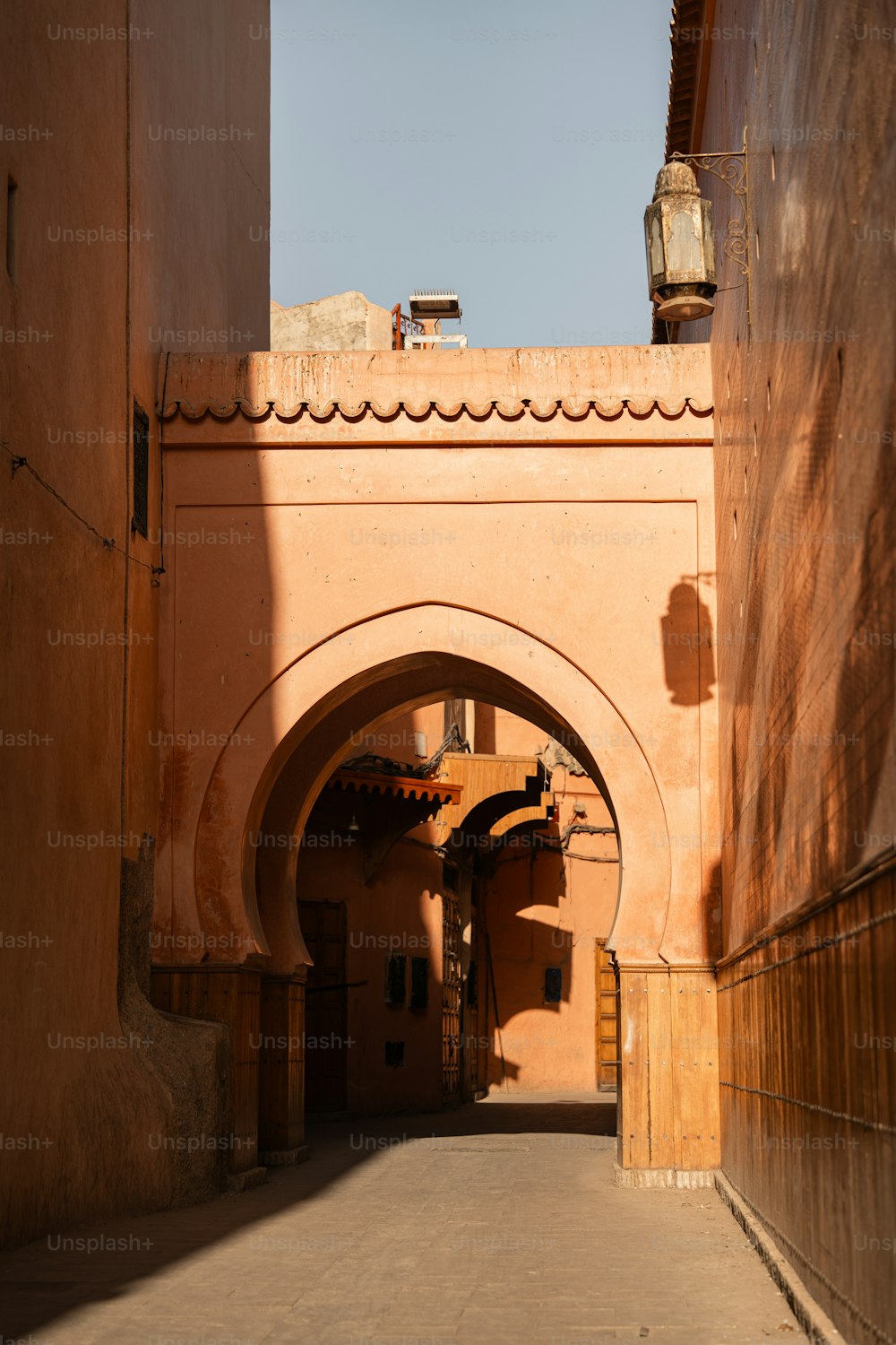 a narrow alley way with a clock on the wall