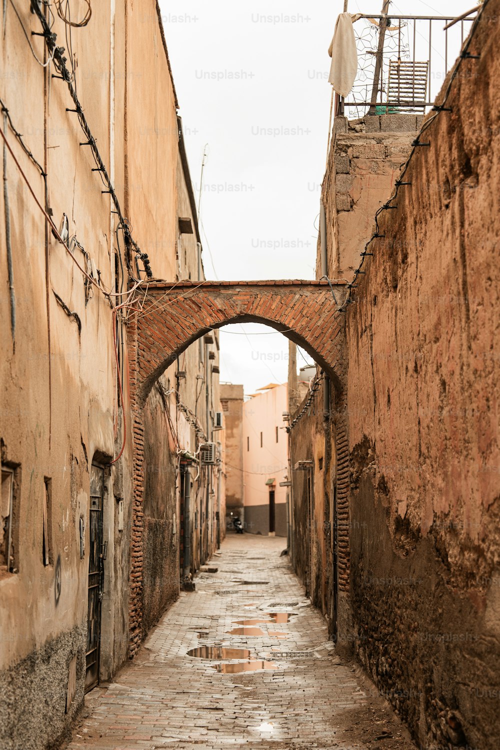 a narrow alley way with a brick bridge over it