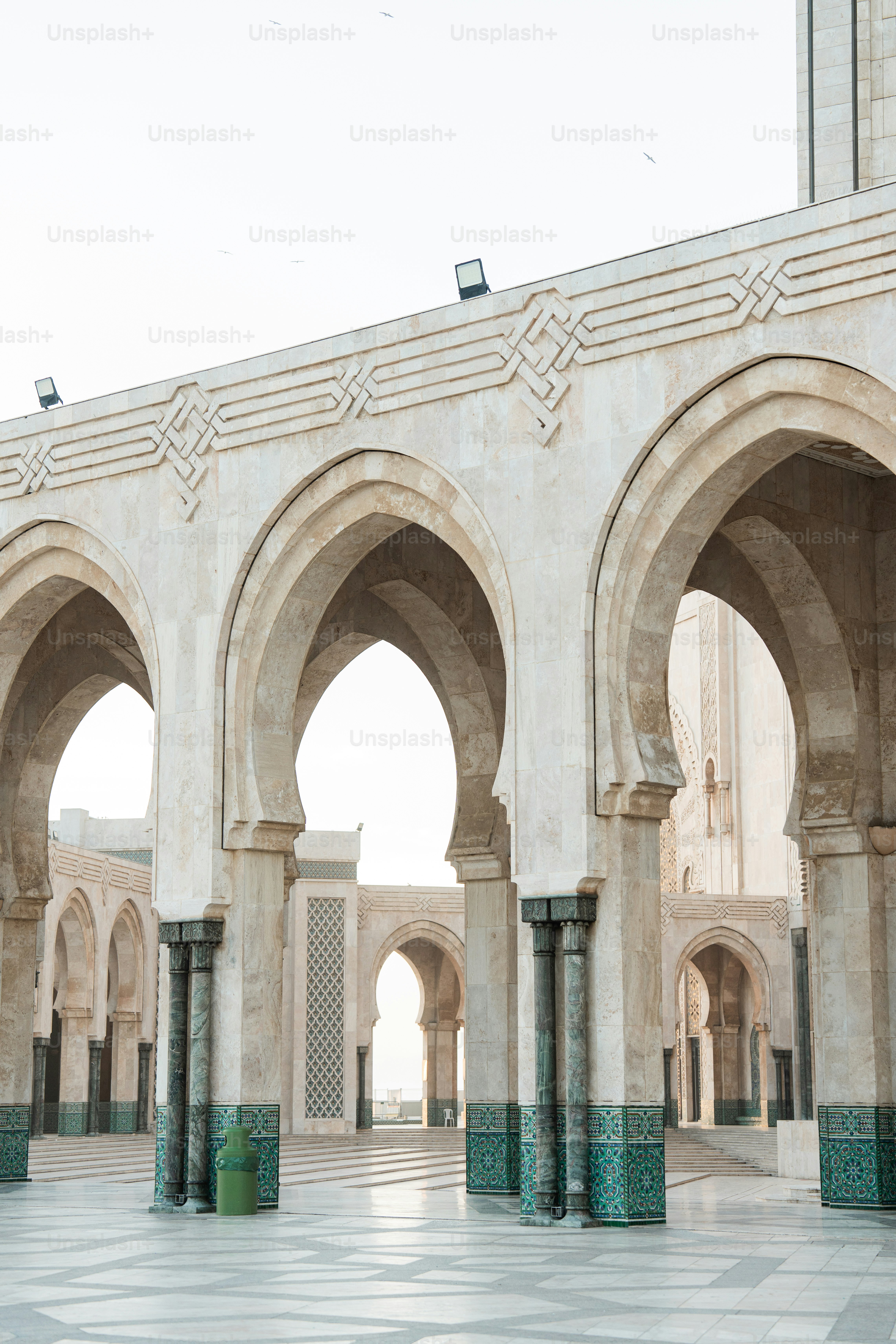a building with arches and a clock tower in the background