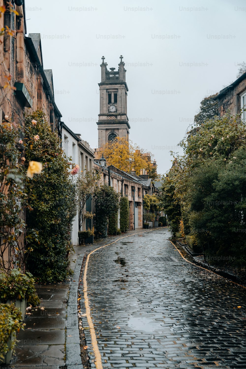 a cobblestone street with a clock tower in the background