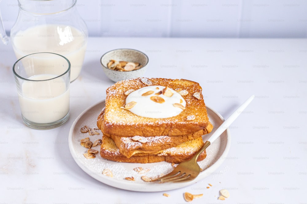 Un piatto bianco condito con french toast ricoperto di zucchero a velo