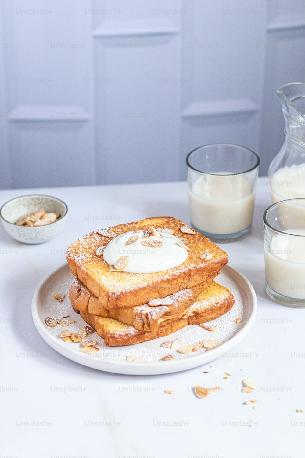 Un piatto bianco condito con french toast ricoperto di zucchero a velo