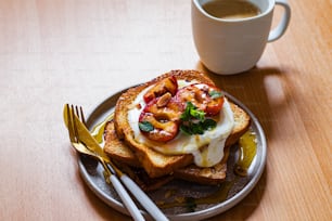 a plate of food on a table next to a cup of coffee