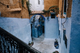 une ruelle étroite aux murs bleus et à la balustrade en fer forgé