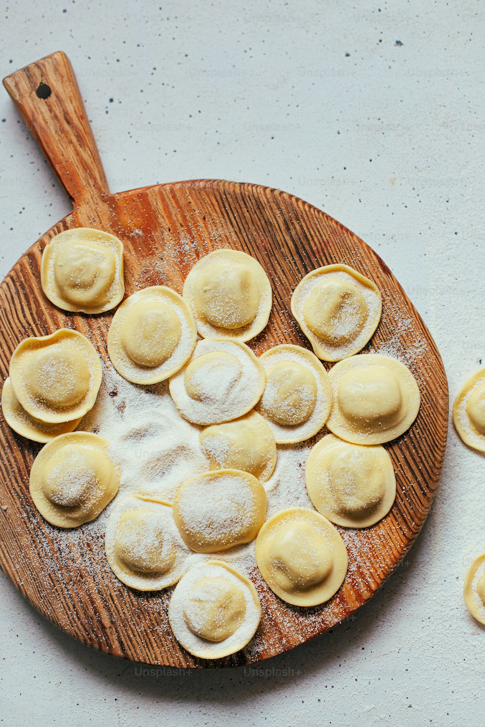 a wooden plate filled with ravioli on top of a table
