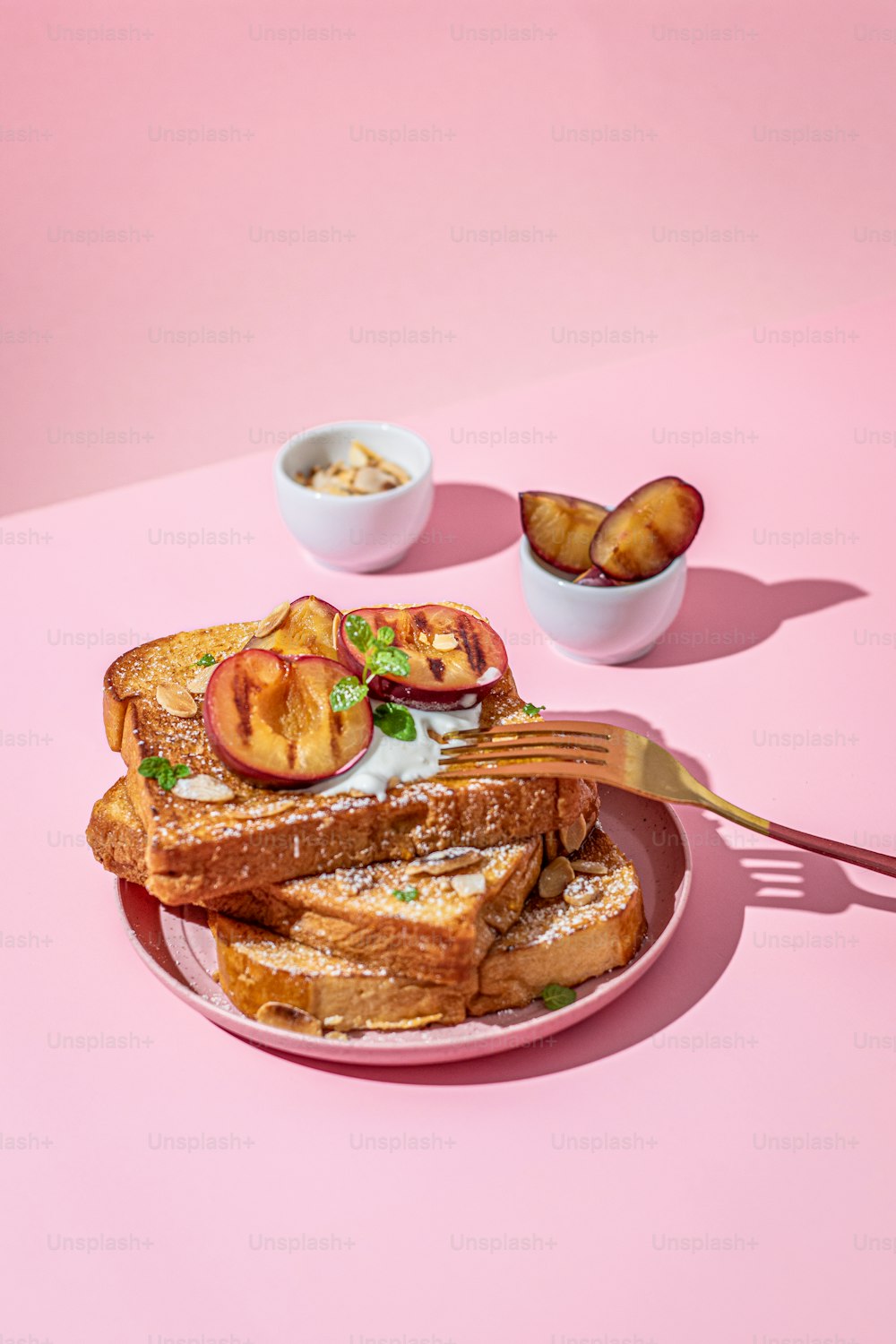 a plate of food with a fork and bowl of fruit