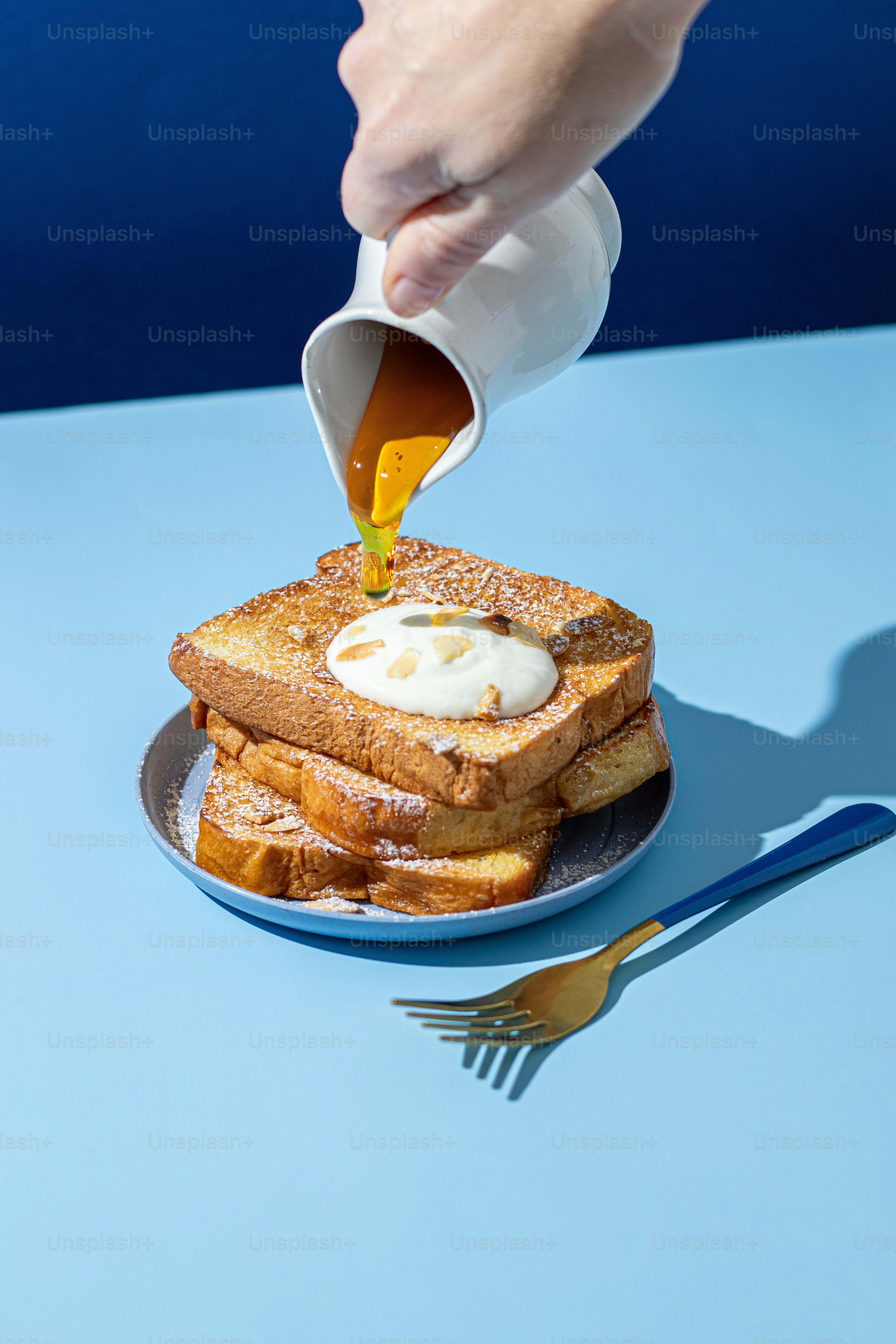 A person pouring syrup on a plate of french toast photo – Food ...