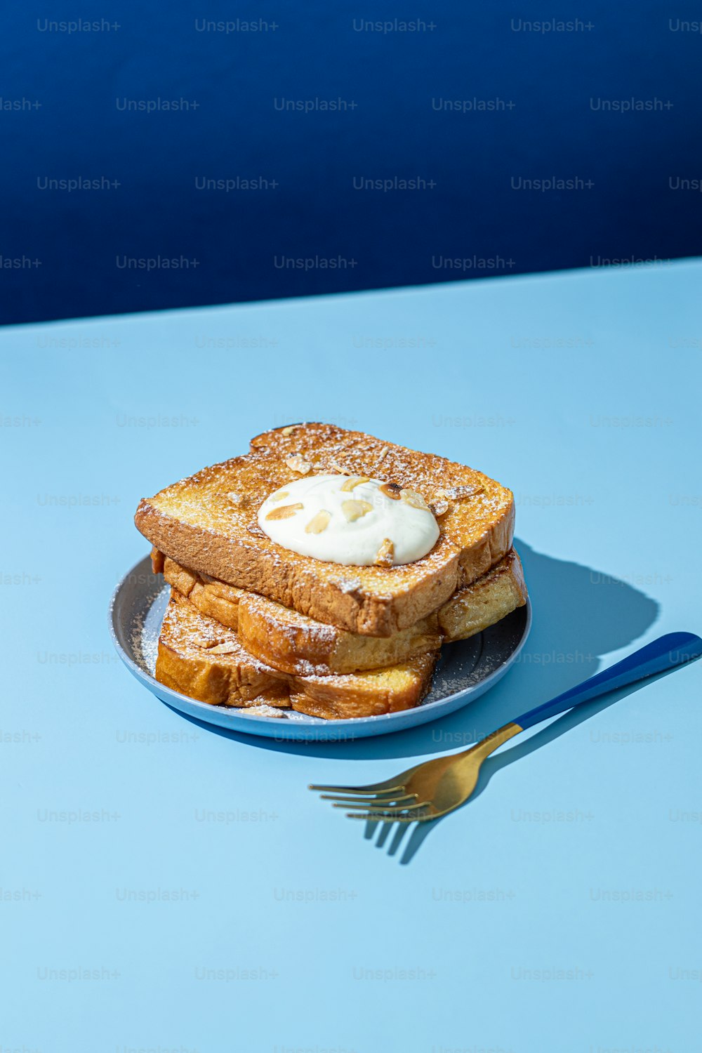 Un piatto blu condito con toast alla francese e panna montata