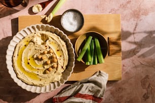 a bowl of hummus next to a bowl of celery