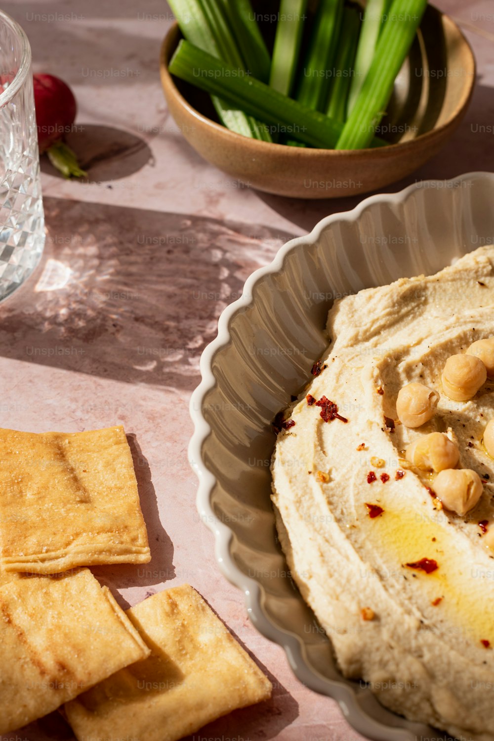 a bowl of hummus and crackers on a table