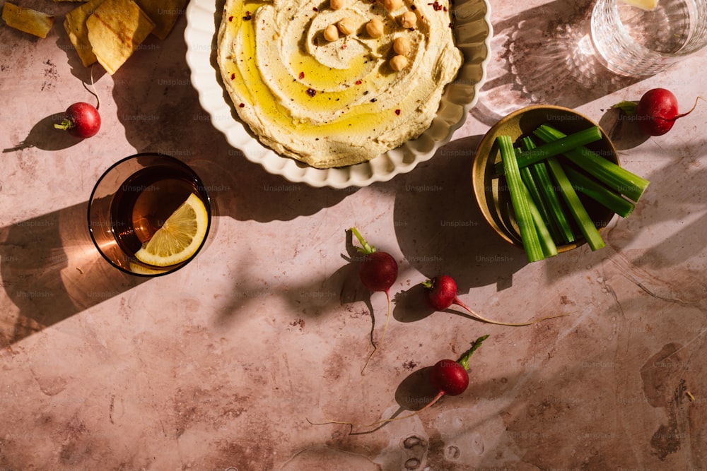 a bowl of hummus next to a bowl of radishes